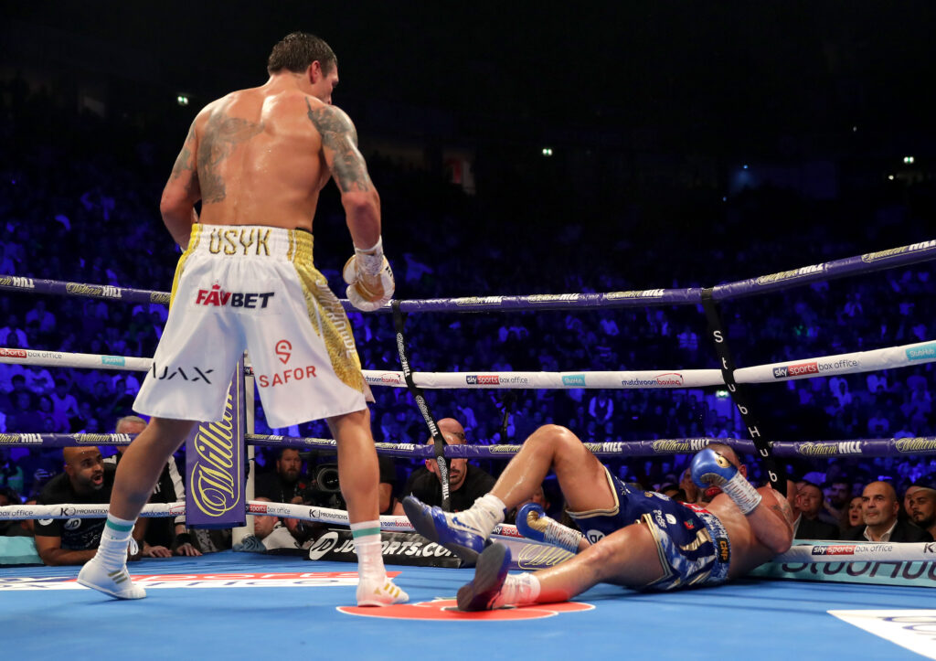 Oleksandr Usyk stands over a fallen Tony Bellew during their world title fight