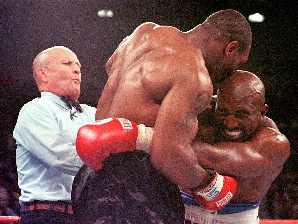 Referee Mills Lane separates Mike Tyson after biting Evander Holyfield's ear during heavyweight title rematch