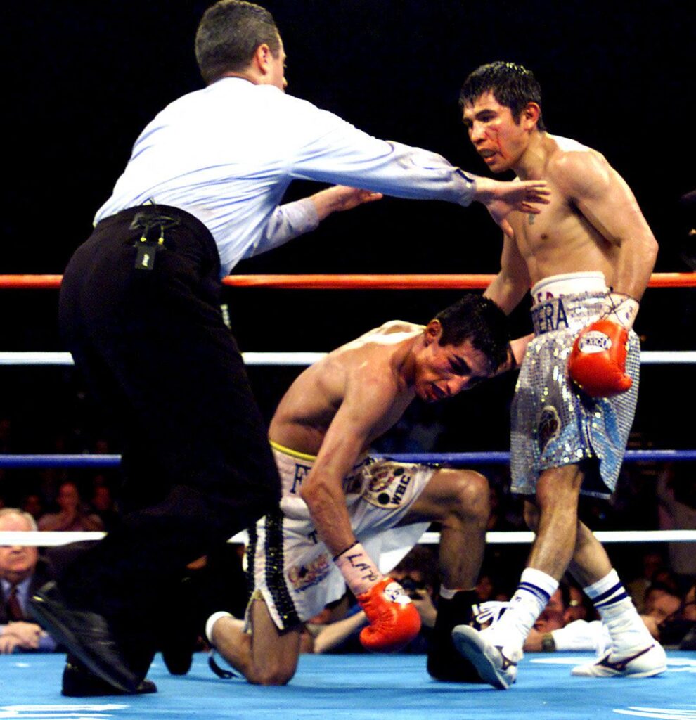 Marco Antonio Barrera sends Erik Morales to one knee in their featherweight title fight