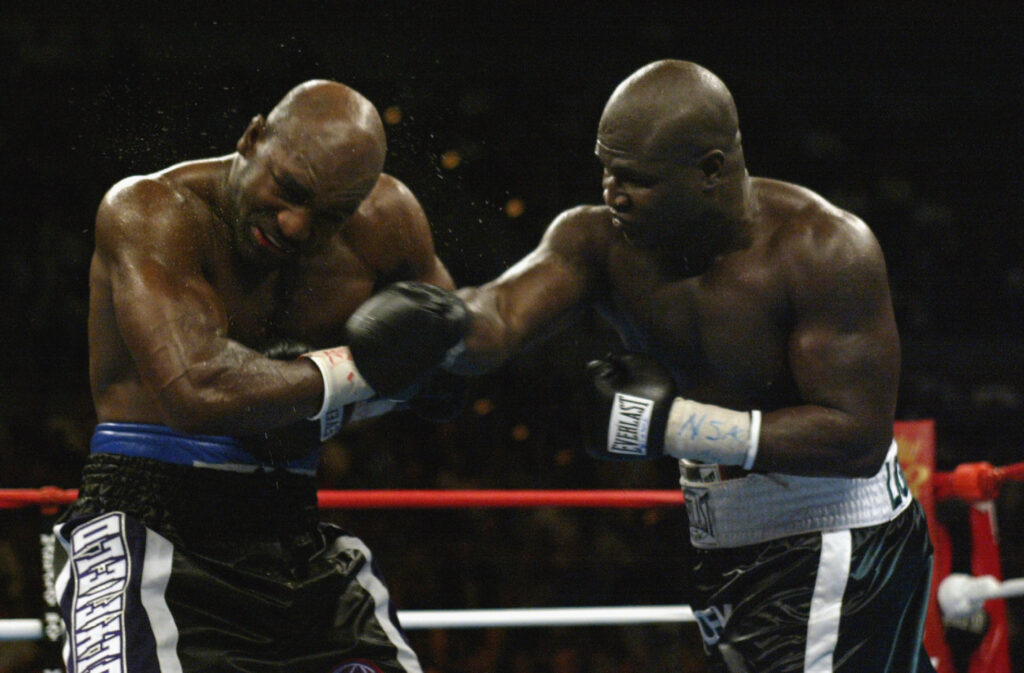 James Toney punches Evander Holyfield in their heavyweight non-title bout in 2003.