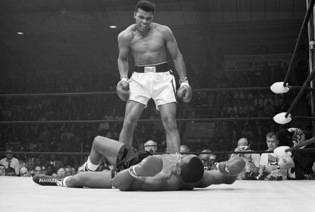 Muhammad Ali taunts Sonny Liston after knocking him down in the first round of their heavyweight title fight in Maine